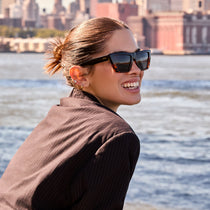 on model - female wearing dime optics melrose cat eye sunglasses with a black tortoise frame and solid grey lenses side view