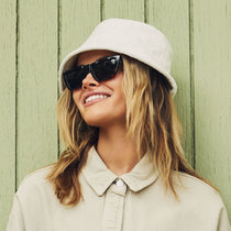 on model - blonde female wearing melrose with a black and tortoise frame and grey lenses sunglasses angled view