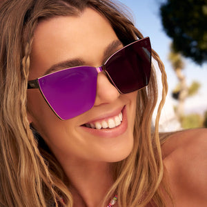 on model - female wearing dime optics glendale cat eye sunglasses with a black frame and candy pink mirror lenses angled view