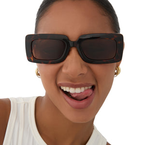 on model - female wearing dime optics featuring the culver rectangular sunglasses with a tortoise frame and brown polarized lenses front view