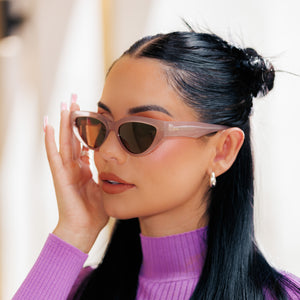 lifestyle - les do makeup wearing last call cat eye sunglasses with a milky nude frame and brown with gold flash polarized lenses close up detailed view