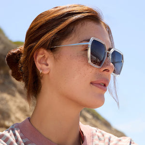 on model - female wearing dime optics featuring the alameda square sunglasses with a silver and crystal clear frame and orchid gradient lenses side view