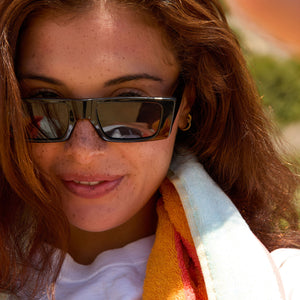 on model - female at the beach wearing les do makeup x dime optics girls night sunglasses with a glossy black frame and grey polarized lenses detailed view