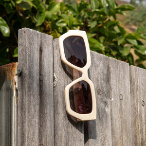 dime optics highland swiss coffee sunglasses hanging on a fence