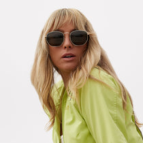 on model - female wearing dime optics roxbury round sunglasses with a gold metal frame and g15 polarized lenses front view