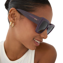 on model - female wearing rissa g x dime optics she's a 10 square sunglasses with a amethyst purple frame and grey gradient polarized lenses side view