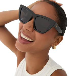 on model - female wearing dime optics featuring the windsor cat eye sunglasses with a black frame and grey polarized lenses angled view