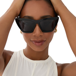 on model - female wearing dime optics featuring the windsor cat eye sunglasses with a black frame and grey polarized lenses front view